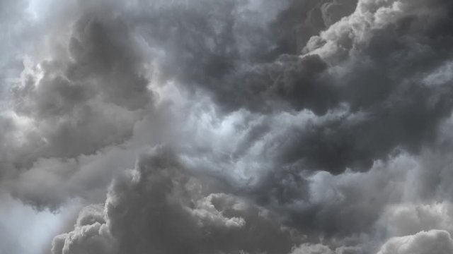 Flying through grey storm clouds. 4K hyper realistic animation of dark grey storm clouds in the sky. Lightning and thunder flashes as the camera travels through the turbulent sky.