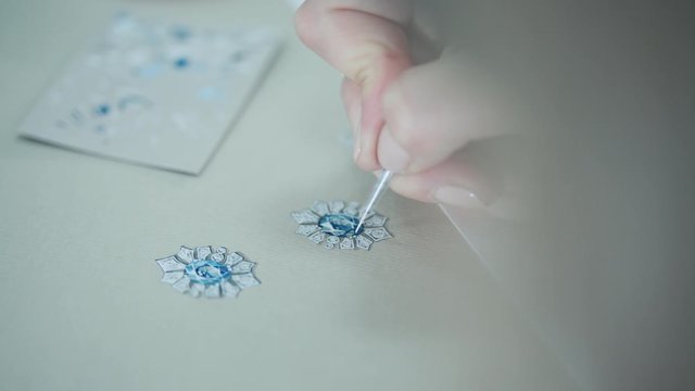 Young woman, a jewelry designer is drawing a sketch for a new ring at a jewelry
