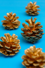 Golden pine cones looking like Christmas trees on blue background