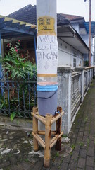 plastic bucket filled with clean water on a wooden table in front of an electric pole. used to wash hands to prevent covid-19 virus in Indonesia