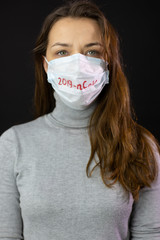 Portrait of a woman scared of coronavirus in medical mask with 2019-ncov written against viruses and infections isolated studio. Coronavirus 2019-ncov covid-19 concept.