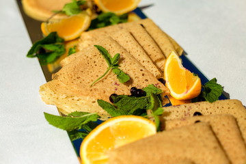 Fototapeta na wymiar pancakes for breakfast with mint and lemon on a white table