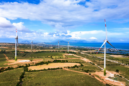 Aerial view of  wind turbines beside sea and coastal road Cam Ranh - Mui Dinh - Ca Na on a sunny day, Phuoc Dinh, Phan Rang, Ninh Thuan, Vietnam. Mui Dinh lighthouse 3 km away from here