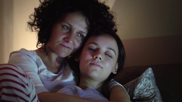 Mother and daughter spending time at home sitting in pijamas, hugging and exchanging emotions during coronavirus quarantine isolation