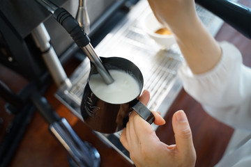 Steam milk for Latte art coffee at cafe