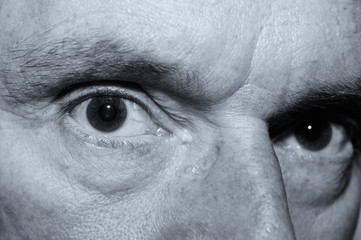 Sinister looking close up of an old mans eyes in monochrome