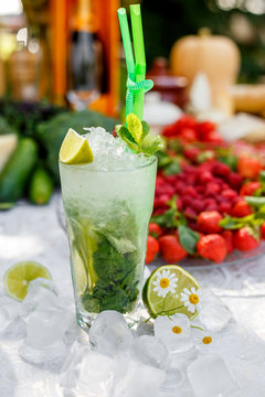Cold cocktail mahito with ice on a decorated table