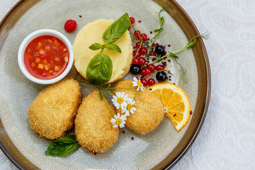 chicken nuggets with mashed potatoes and sauce on a decorated table