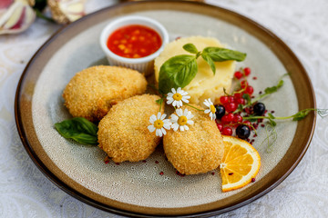 chicken nuggets with mashed potatoes and sauce on a decorated table