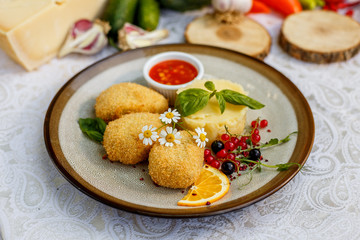 chicken nuggets with mashed potatoes and sauce on a decorated table