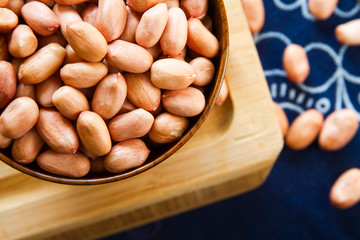 Whole peanut kennel in a wooden bowl close up