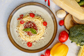 Pasta bolognese with minced meat and tomatoes with greens on the decorated table
