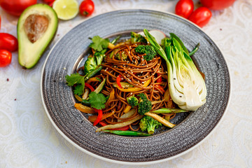 Noodles with wood mushrooms, soy sauce and vegetables on a decorated table
