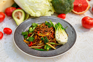 Noodles with wood mushrooms, soy sauce and vegetables on a decorated table