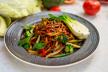 Noodles with wood mushrooms, soy sauce and vegetables on a decorated table