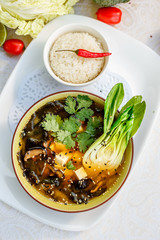 Thai soup tom yam with seafood and cheese on decorated table