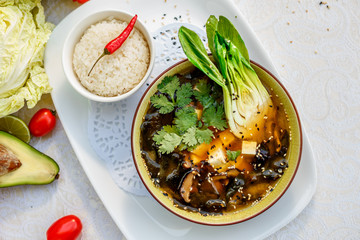Thai soup tom yam with seafood and cheese on decorated table