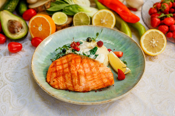 Grilled fish with mashed potatoes and vegetables on the decorated table