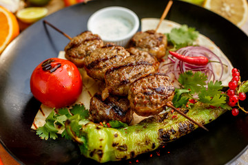 kebab with pita bread and grilled vegetables on a decorated table