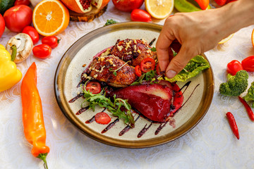 chicken thighs with rucola, nuts and vegetables on a decorated table