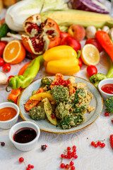 broccoli fried in breading with vegetables with sauces on a decorated table