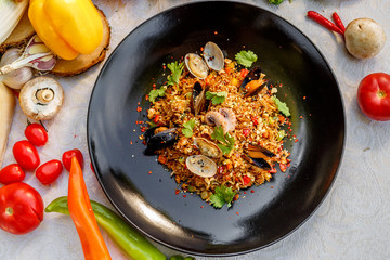 risotto rice with seafood, octopus mussels and vegetables with sauces on the decorated table