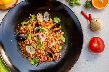 risotto rice with seafood, octopus mussels and vegetables with sauces on the decorated table