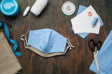 Painting, fabrics and sewing accessories for sewing an anti-virus mask. Do it yourself. Zero waste and quarantine concept. Homemade facemask against virus infection in detail. Top view