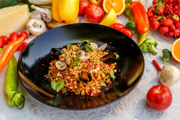 risotto rice with seafood, octopus mussels and vegetables with sauces on the decorated table