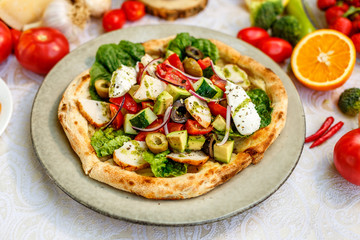 salad with chicken cheese and vegetables on a flat cake on a decorated table