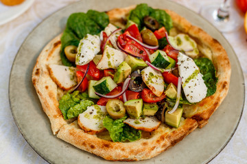 salad with chicken cheese and vegetables on a flat cake on a decorated table