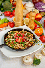 buckwheat with mushrooms, green onions and vegetables on the decorated table