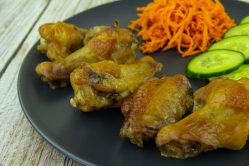 Spicy salad of carrots, cucumbers and fried chicken wings