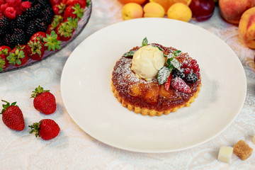 dessert, belgian waffle with a scoop of ice cream and berries in a white plate on a white table