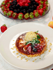 dessert, belgian waffle with a scoop of ice cream and berries in a white plate on a white table