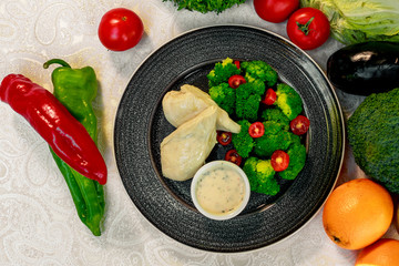 boiled chicken breast with broccoli and tomatoes with sauce, healthy food in a white plate on a white table