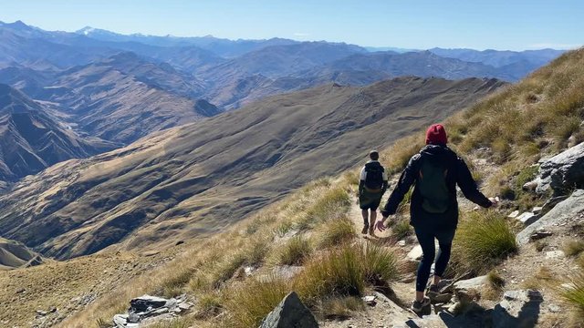 People hiking on a trek across hills and mountains in New Zealand