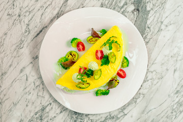 omelet with cheese and vegetables on a white plate