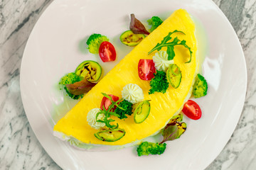 omelet with cheese and vegetables on a white plate