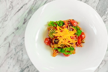 fried tofu with sesame seeds and vegetables on a white plate