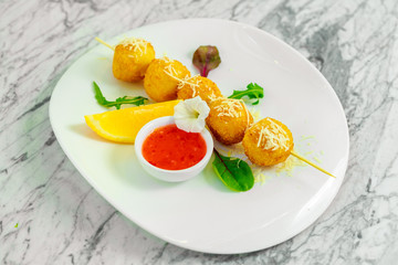 skewered cheese balls with sauce and lemon