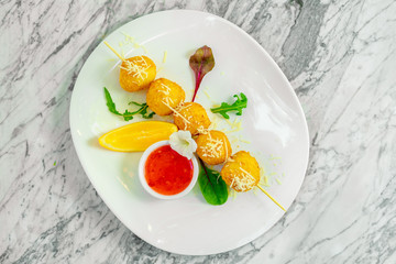 skewered cheese balls with sauce and lemon