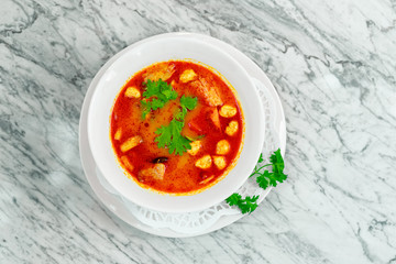 soup with chicken, mushrooms and herbs on a white plate, a beautiful serving