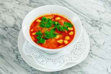 soup with chicken, mushrooms and herbs on a white plate, a beautiful serving