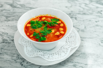 soup with chicken, mushrooms and herbs on a white plate, a beautiful serving