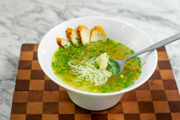 soup with chicken, mushrooms and herbs on a white plate, a beautiful serving