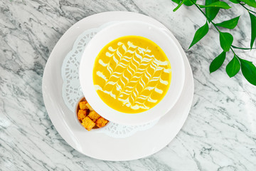 cheese soup with crackers on a white plate, beautiful serving