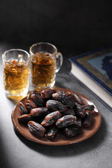 dates fruit and Islamic Book Koran on a concrete background, Islamic background in ramadan