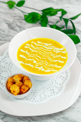 cheese soup with crackers on a white plate, beautiful serving