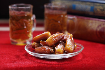 Dates fruit and Islamic Book Koran on carpet background, Islamic background in mosque
